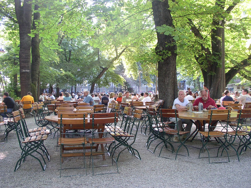 Photo of patrons enjoying beers and Bavarian food at a Munich beer garden