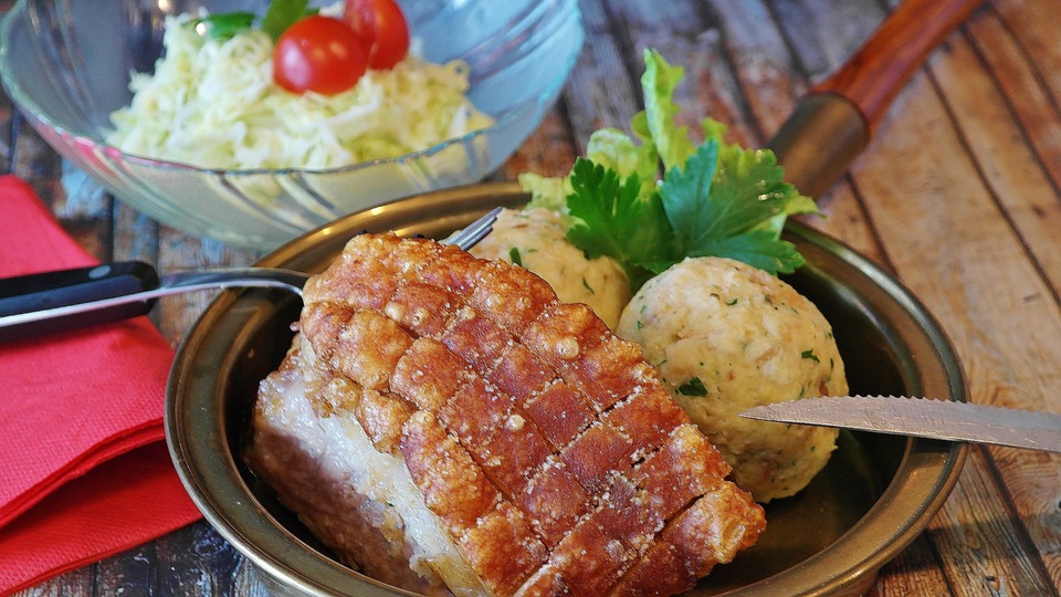 Photograph of traditional Bavarian roast pork and dumplings dish Schweinebruten