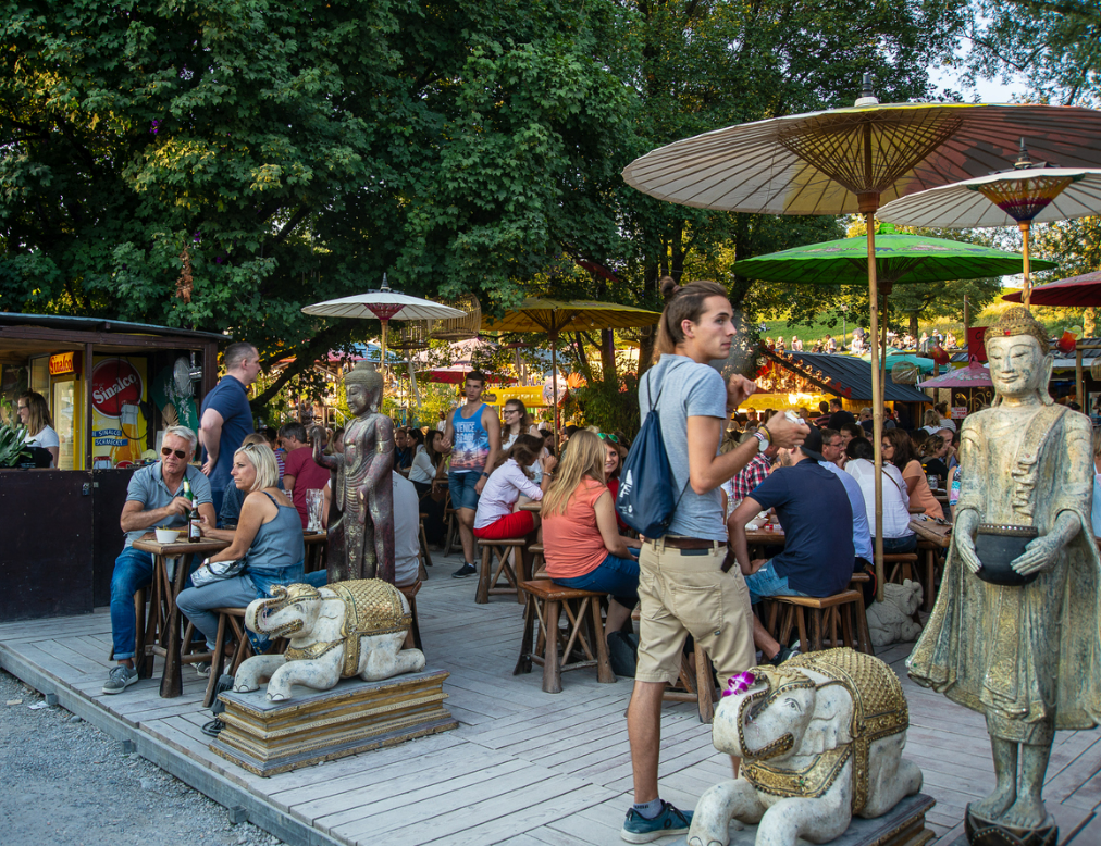photo of people enjoying drinks and snacks on a terrace at Munich’s Tollwood Festival