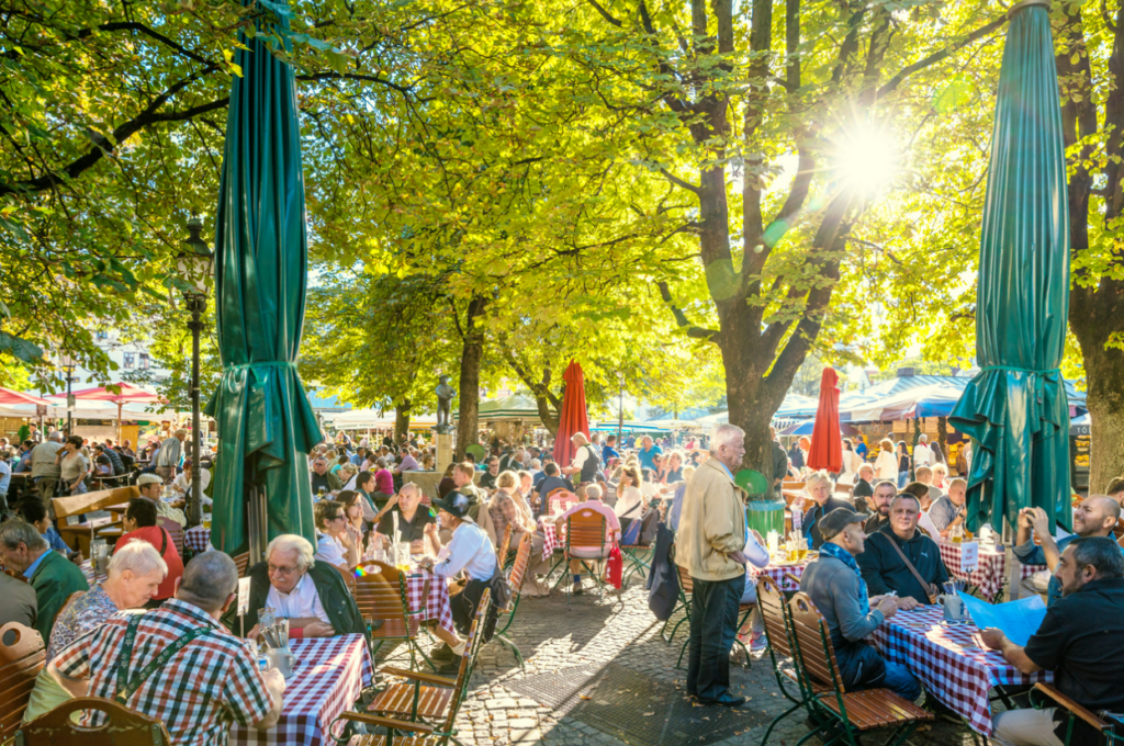 photo of people eating and drinking outdoors at the Viktualienmarkt in Munich