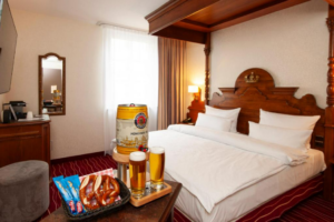 photo of a room at KING’s Hotel First featuring a keg of Bavarian beer, two full glasses of beer and Bavarian snacks